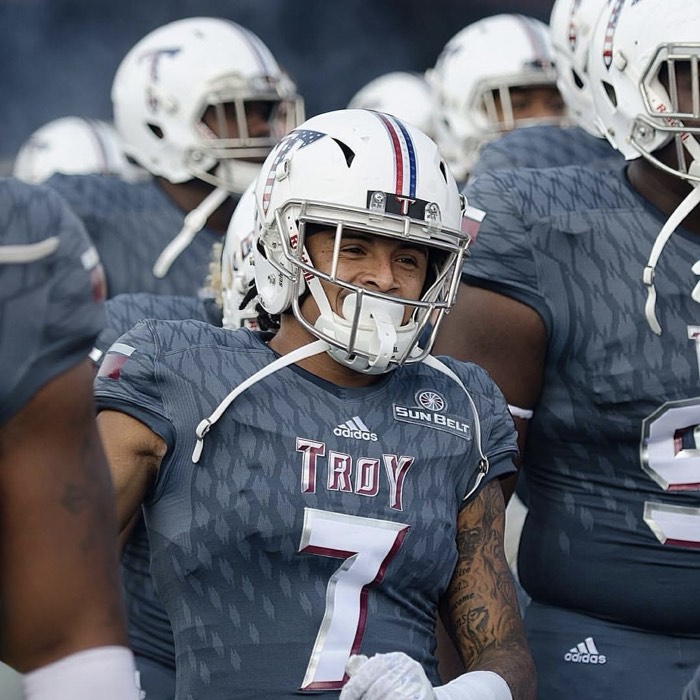 Hiram Velez in the huddle in a Troy University uniform.