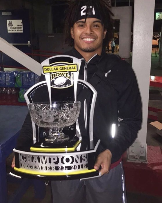 Hiram Velez holding the 2016 Dollar General Bowl championship trophy.